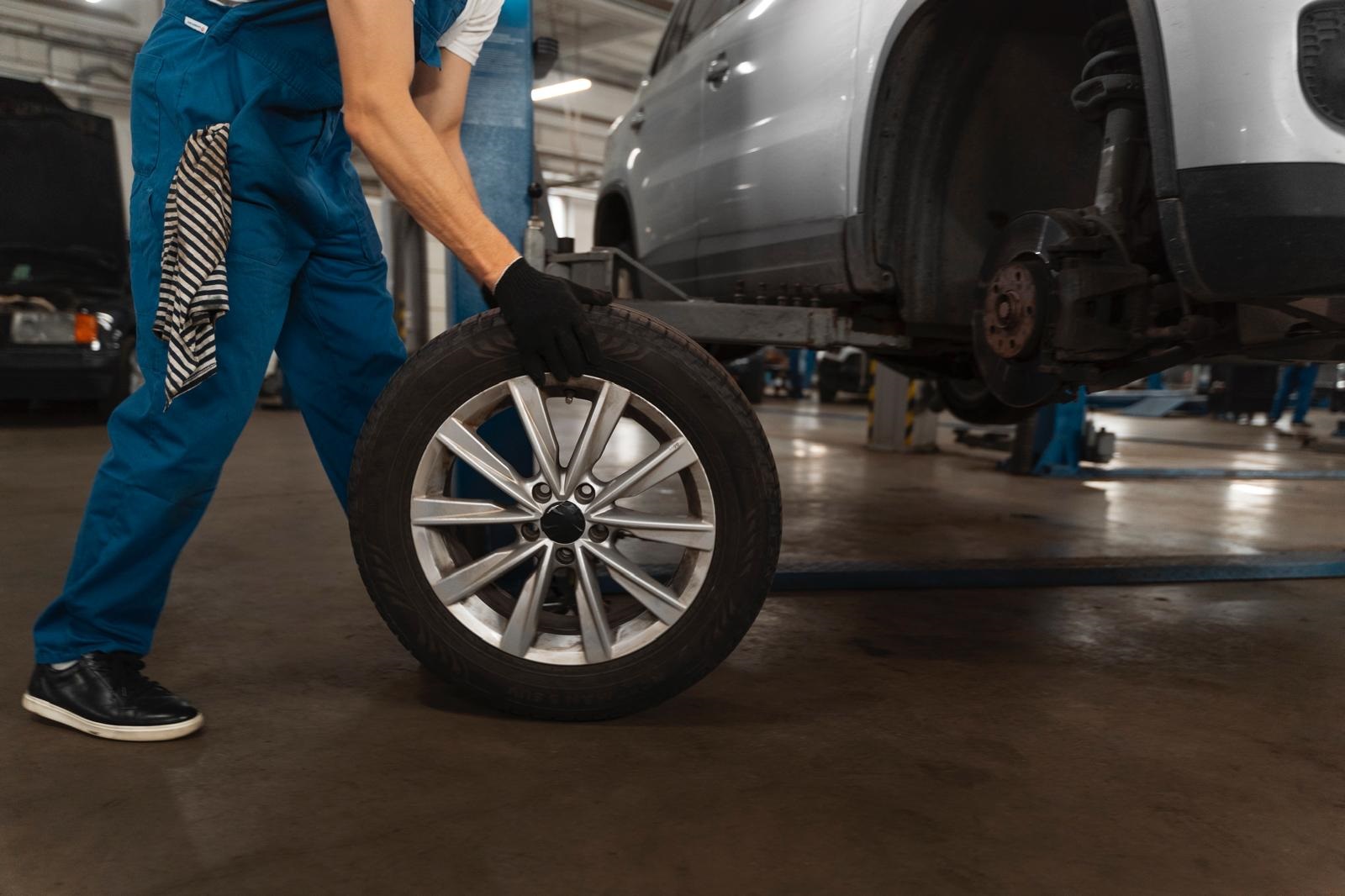 Mecánico manipulando rueda de coche en un taller