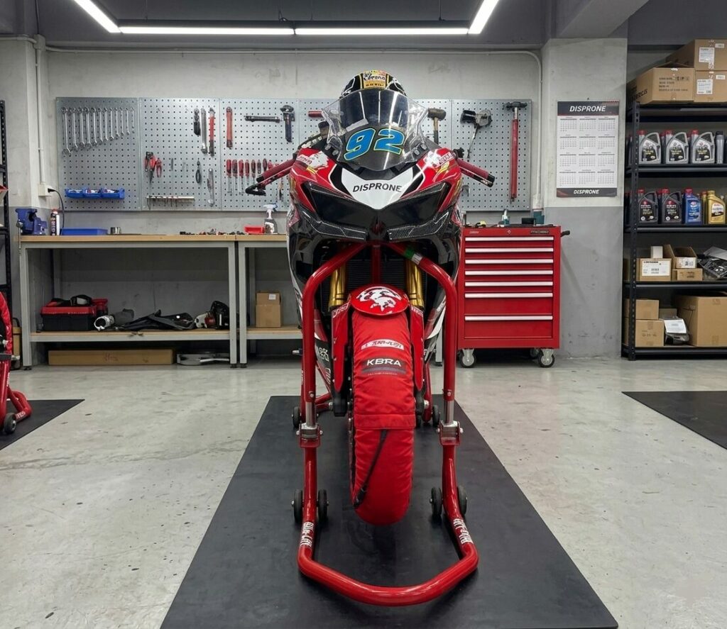 Caballete frontal tija Bike-Lift FS-11 elevando una moto deportiva en un taller profesional de Disprone sobre alfombrilla técnica negra.